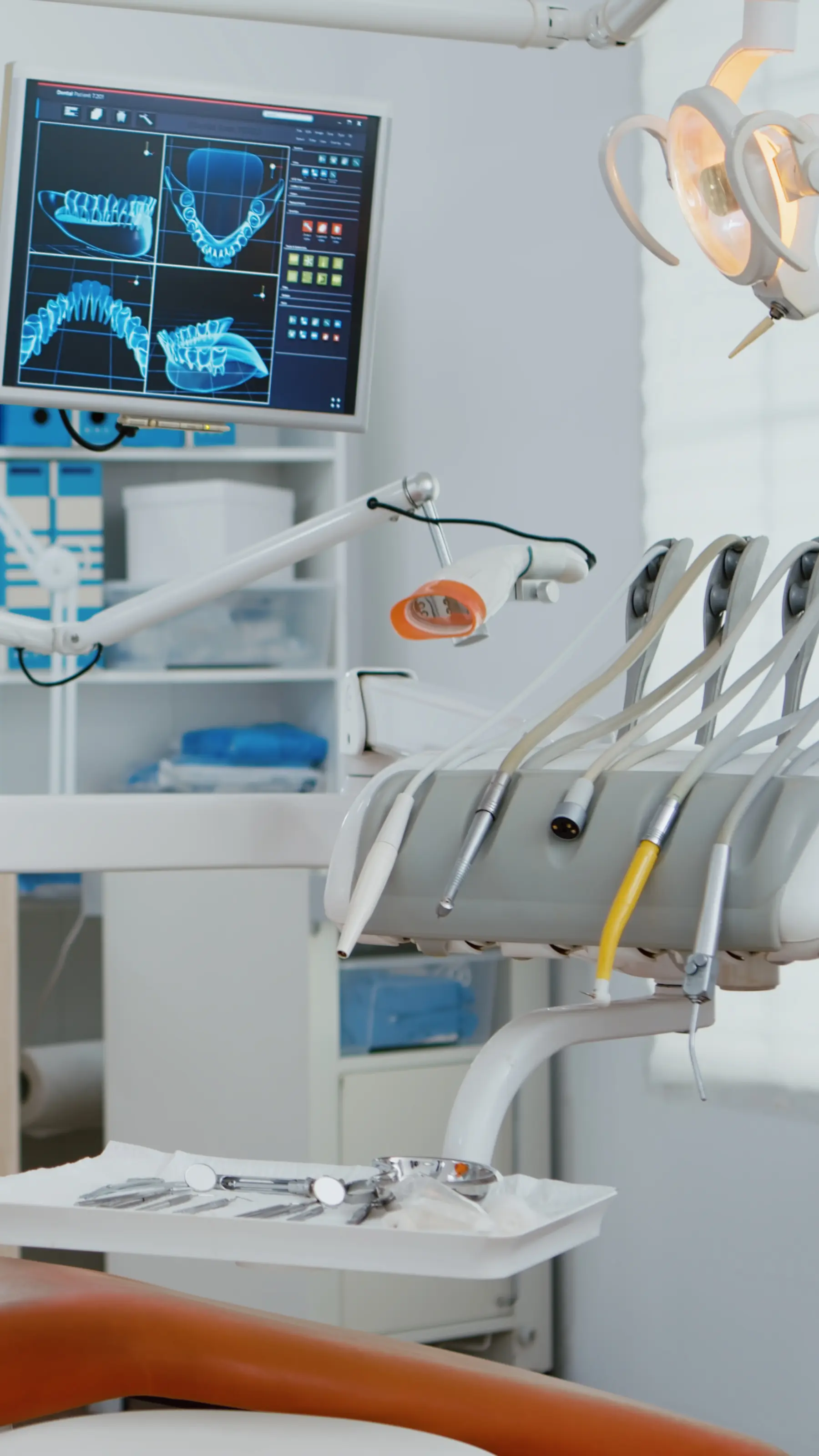 Un gabinete dental equipado, con el sillón y las pantallas encendidas